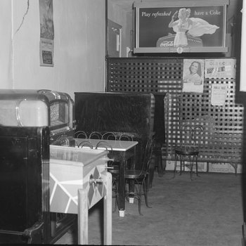 Inside of Quedens Lunch Billiards, New Market, Va. View of the back of the restaurant, with a pinball machine, jukebox, and tables shown.