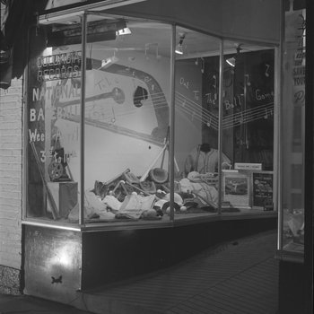 The front window of Hodgin's Store (electronics and sporting goods) in Woodstock, Va. Window advertises National Baseball Week, April 3-10.