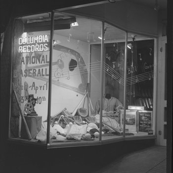 The front window of Hodgin's Store (electronics and sporting goods) in Woodstock, Va. Window advertises National Baseball Week, April 3-10. 2