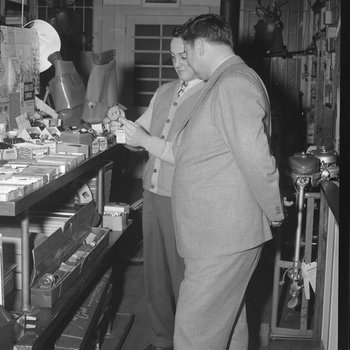 Inside Hodgin's Store, two men examining a piece of merchandise, possibly a fishing reel. Woodstock, Va.