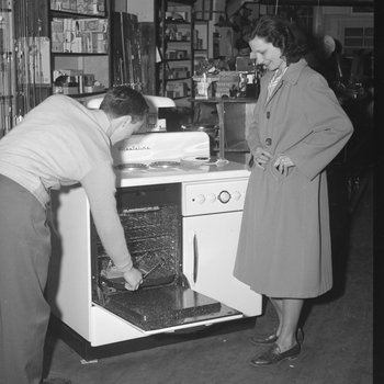 Inside Hodgin's Store, a man showing a woman a 3-in-1 stove, oven, and dishwasher. Woodstock, Va.