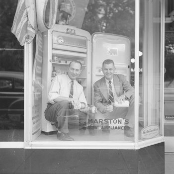 Marston's Home Appliance Store, view of two men pouring drinks in the window display. 2