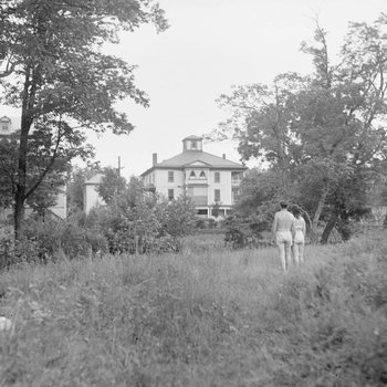 Shenandoah Alum Springs Hotel, distant view with two people walking towards it. Orkney Springs, Va.