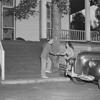 A man and woman shaking hands on the steps of the Shenandoah Alum Springs Hotel, Orkney Springs, Va.