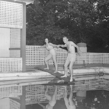 Two people standing on the diving board of the swimming pool at the Shenandoah Alum Springs Hotel. Orkney Springs, Va.