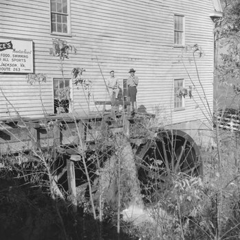 Bryce's Mountain Resort, side view of two men standing on the water wheel. Basye, Va.