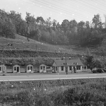 Ike's Tourist Camp, roadside cabins with a Texaco service station, distant front view.