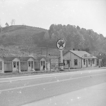Ike's Tourist Camp, side view of a Texaco sign and roadside cabins.
