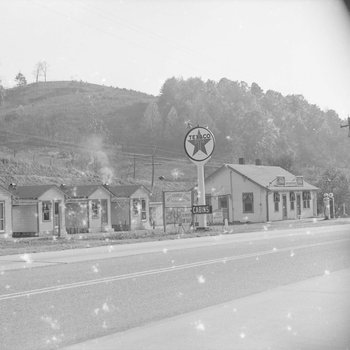 Ike's Tourist Camp, side view of a Texaco sign and roadside cabins. 2