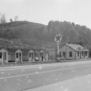 Ike's Tourist Camp, side view of a Texaco sign and roadside cabins. 3