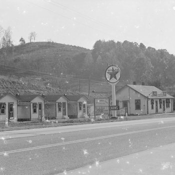Ike's Tourist Camp, side view of a Texaco sign and roadside cabins. 4