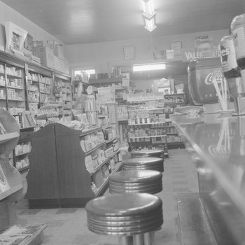Alternate view of shelving inside of a store or building with a refreshment counter pictured.