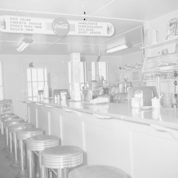Inside of a diner, view of the counter and menu.