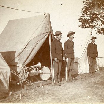 Three U.S. soldiers in uniform outside their tents (1997.149.1)