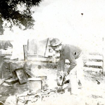 Cook cleaning up at a campfire site (MSS 31 B3 F8 #18f)