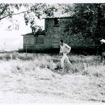 Gordon Parks, Jr. walking in front of the house used on location during the filming of "The Learning Tree" on location in Bourbon and Linn counties, Kansas