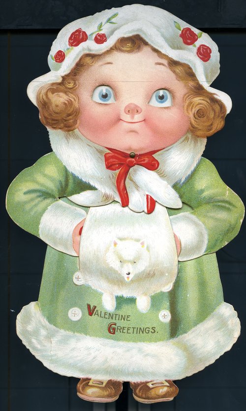 A plump blue-eyed girl in a green coat, white hat, and a white muff. Text: Valentine Greetings.