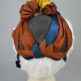 Bonnet, black straw capote trimmed with blue velvet, silk ribbons in blue and dark orange, and artificial flowers, 1880s, back view