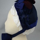 Bonnet, blue felt capote with blue velvet, blue feather trim, and velvet ribbon in blue and burgundy, 1880s, front view