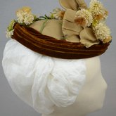 Toque, oval shape with cream ribbon, brown velvet, and artificial flowers, 1890s, side view