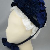 Bonnet, blue straw capote with velvet trim and feather puffs, 1870s-1880s, left side view