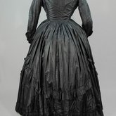 Dress, black plain weave silk with ruffles, c. 1870, back view
