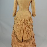 Dress, amber silk taffeta with chenille-fringed barege overdress, c. 1880, back view