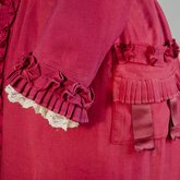 Housedress, cranberry red wool with self-trims, 1880s, detail of cuff and pocket