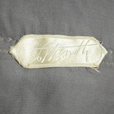 Dress, gray silk satin with a netted silver bead overlay and gray chiffon panels, 1921-1925, detail of label