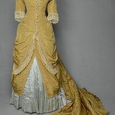 Dress, deep yellow silk taffeta with blue silk satin pleats and long train, 1877-1882, front view with restored seams and darts