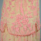 Sheath dress, sleeveless with irregular hem, apricot chiffon with pink and coral beads, c. 1925, detail of beading
