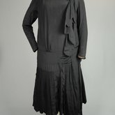 Dress, black silk with dropped waist and scalloped pleated panels, 1920s, front view