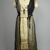 Dress, cream satin with black chiffon overlay and tasseled, embroidered panels, c. 1910s (refurbished), front view