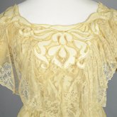 Evening gown, pale yellow faille with Chantilly lace and a bobbinet overlay appliquéd with Art Nouveau lilies, c. 1905, detail of front bodice