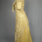 Evening gown, pale yellow faille with Chantilly lace and a bobbinet overlay appliquéd with Art Nouveau lilies, c. 1905, side view