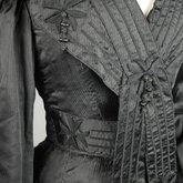 Suit, black ottoman silk trimmed with Maltese crosses and tassels of silk-wrapped beads, 1915-1917, detail of bodice front and collar