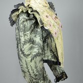 Bodice, black lace over green faille and pale green organdy with shoulder frills, pink beaded flowers, and sequins, c. 1898, side view
