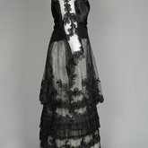 Dress, black silk satin and point d’esprit bobbinet with organdy and cord appliqué, c. 1915-1918, side view