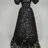 Evening gown, Marie Lamy of Paris, black silk satin with a black-sequined overlay and short puffed sleeves, 1890s, back view