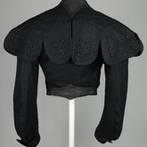 Jacket, black wool with large scalloped revers, pouched front, and topstitched silk trim c. 1902, back view