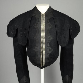 Jacket, black wool with large scalloped revers, pouched front, and topstitched silk trim, c. 1902, front view