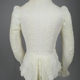 Shirtwaist, white embroidered cotton with ruffles flanking the buttoned front, 1884, back view