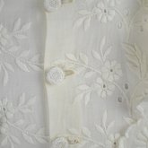 Shirtwaist, white embroidered cotton with ruffles flanking the buttoned front, 1884, detail of button and embroidery