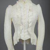 Shirtwaist, white embroidered cotton with ruffles flanking the buttoned front, 1884, front view