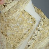 Dress, cream wool trimmed with lace, pink velvet, and multi-colored machine embroidery, 1908, detail of upper bodice closure unhooked