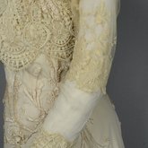 Dress, House of Rouff, cream wool with lace-draped bodice and sleeves, trimmed with cording, ribbon fronds, and roses, c. 1905, detail of sleeve