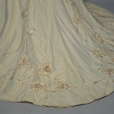 Dress, House of Rouff, cream wool with lace-draped bodice and sleeves, trimmed with cording, ribbon fronds, and roses, c. 1905, detail of train