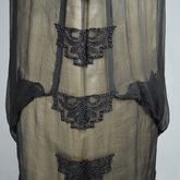Dress, House of Worth, black silk chiffon and cream silk satin with cream lace, 1910-1915, detail of front of skirt lace and drape