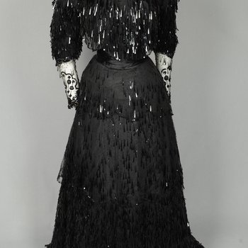 Evening gown, House of Rouff, black silk taffeta and satin with layered black net overlays embroidered with elongated black spangles and round sequins, c. 1905, front view