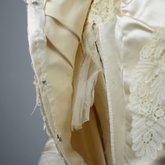 Wedding dress, cream silk satin and lace with long sleeves and a train, c. 1905, detail of padding between satin and lining